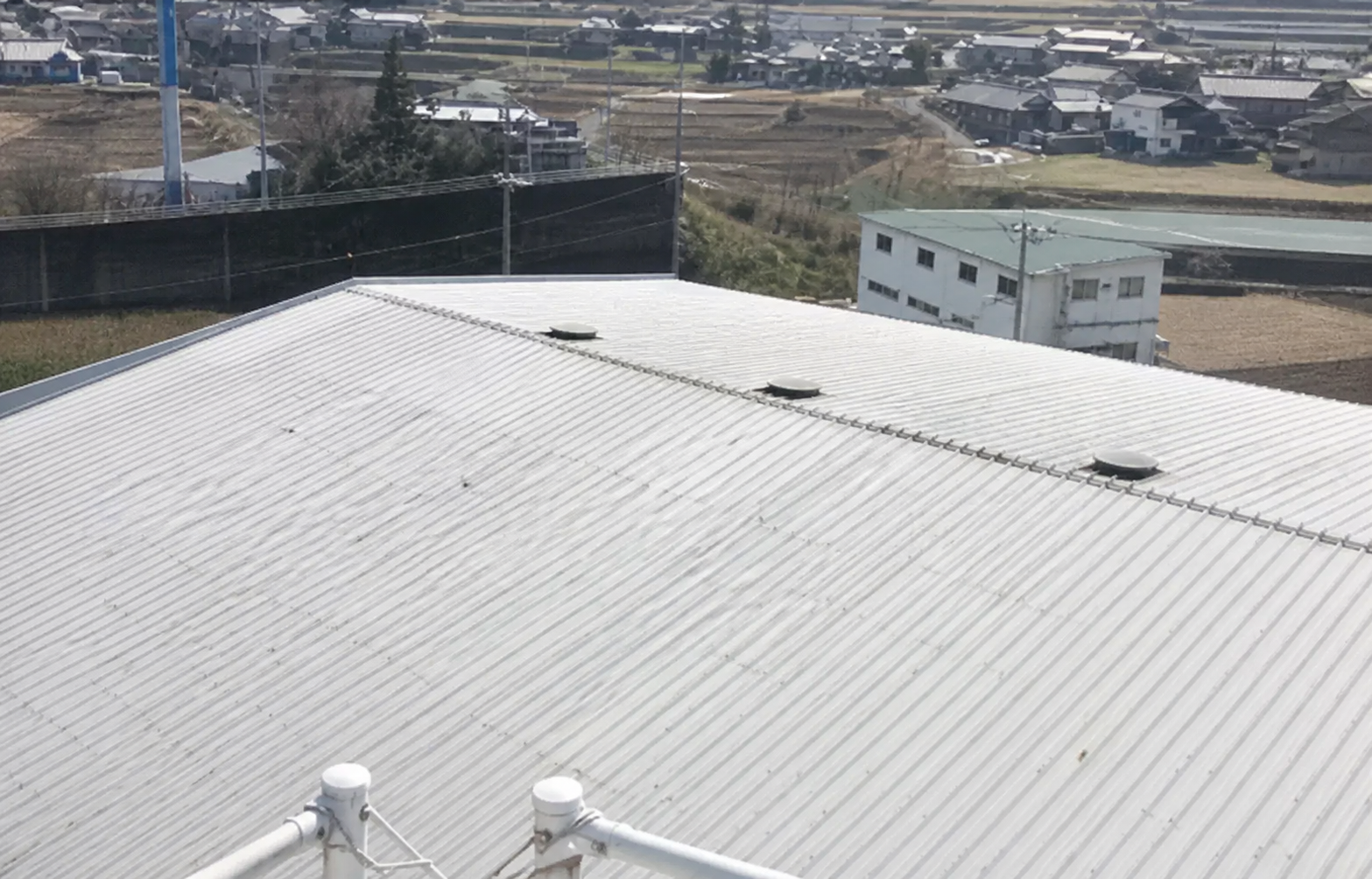 折板屋根・施工13年後（視認性向上のため手前の樹木を画像処理）